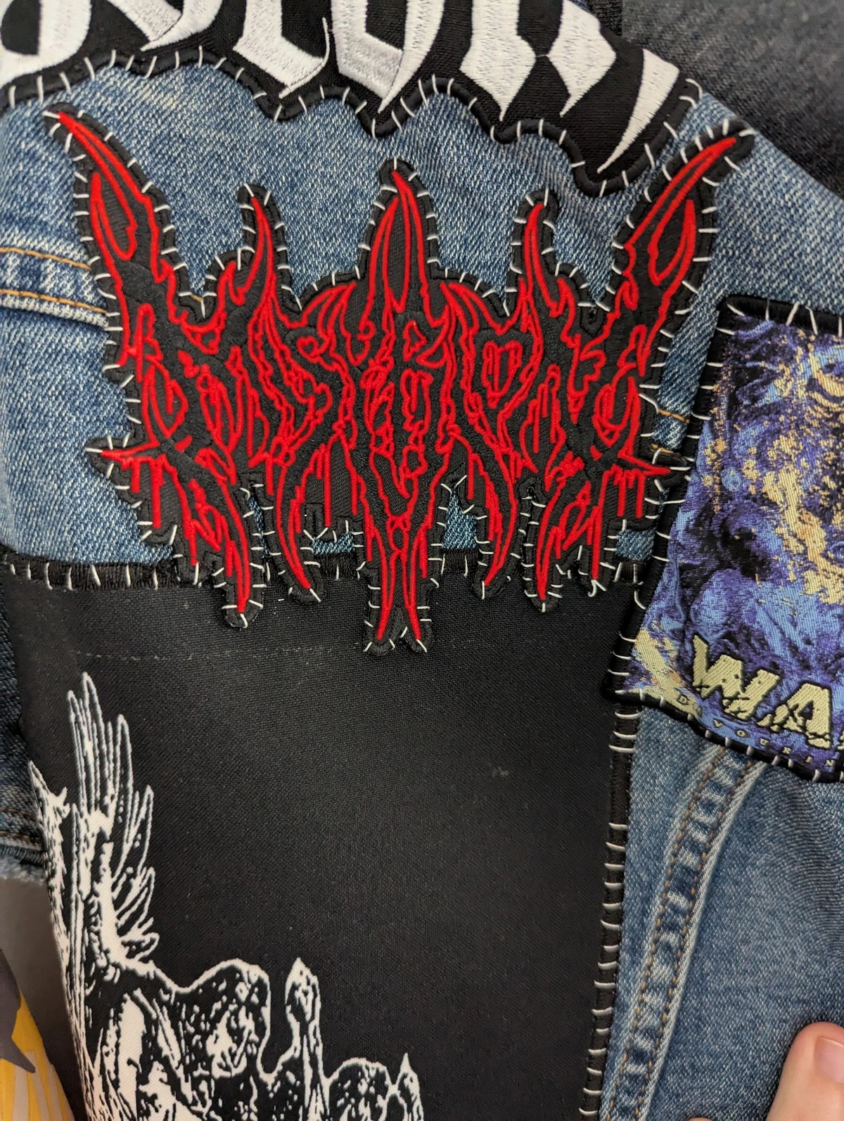 Denim Vest with band patches sewn on.