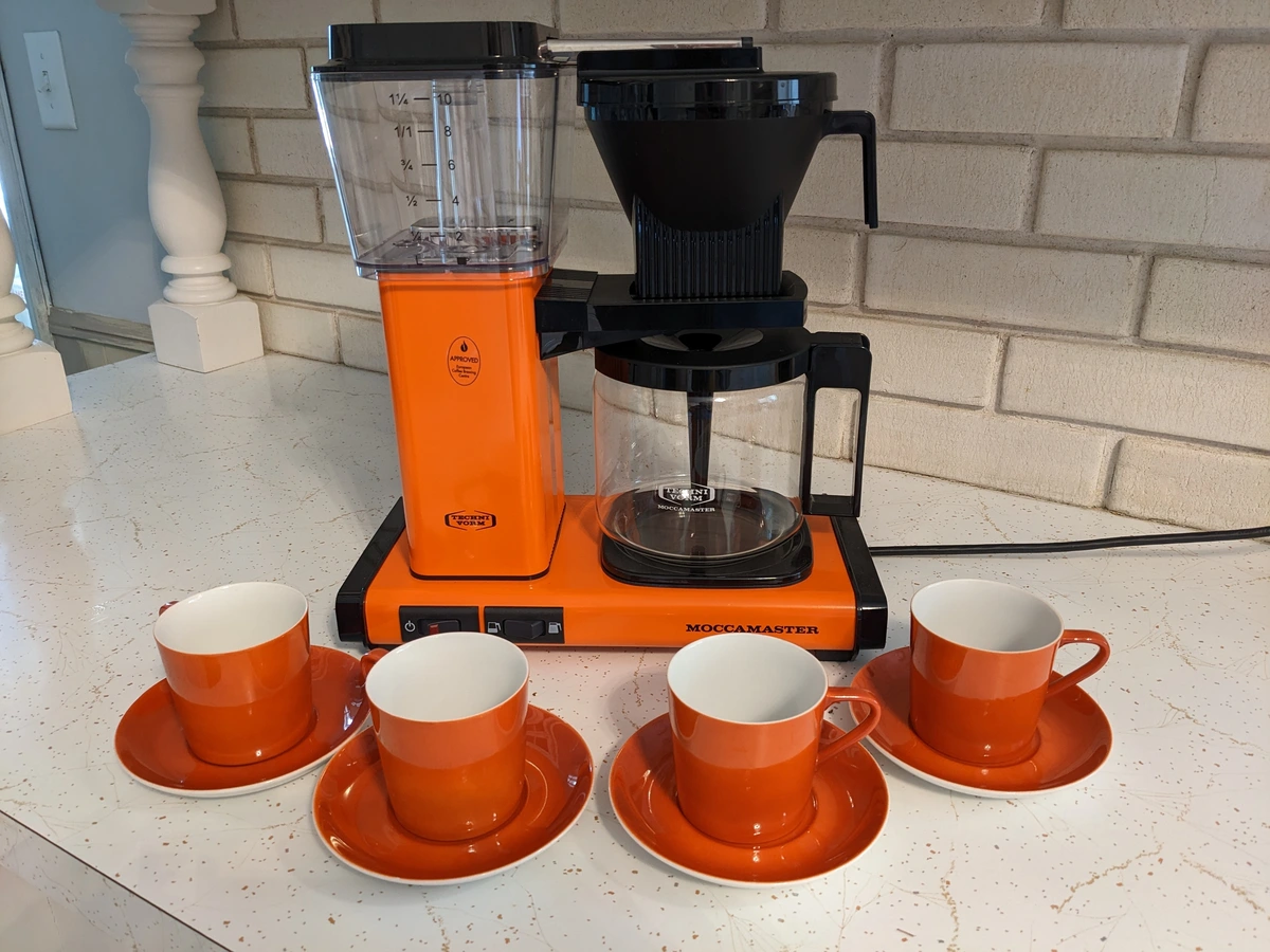 orange coffee pot with it's orange cups.