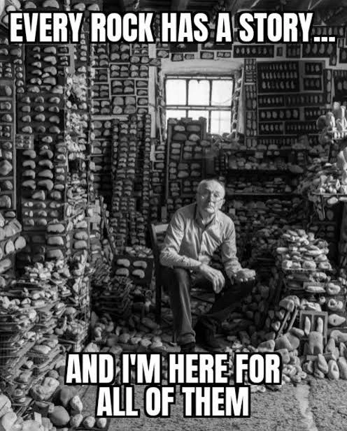 Black and white photograph of an old man sitting on a wooden chair, holding a stone in one hand, in this middle of a room where every shelf ans surface is covered in rocks. Text overlay reads in white: Every rock has a story... And I'm here for all of them.